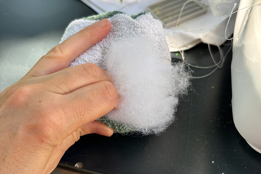DIY-Wasserbomben nähen — Nähmaschine mit Frottee-Stoff in Nahaufnahme